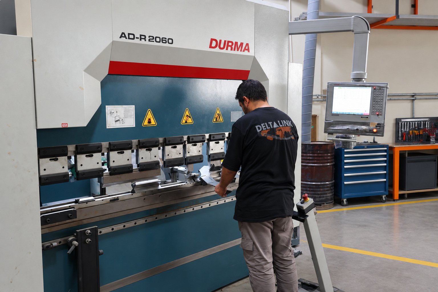 Deltalink technician operating a CNC press brake for controlled sheet metal forming.